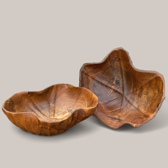 Zwei handgefertigte Teakholz-Schalen von INDOO.art mit unterschiedlichen organischen Formen, die nebeneinander präsentiert werden – einzigartige Dekorstücke mit natürlicher Holzmaserung für stilvolle Wohnräume.